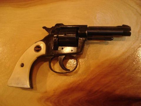 1995 Ford Bronco - A close-up view of a revolver with white grips rests on a wooden table.