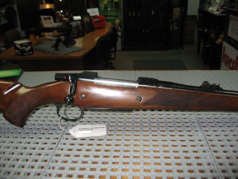 1991 Ford Bronco - Close-up of a rifle's side profile, a wooden stock and visible bolt action mechanism.
