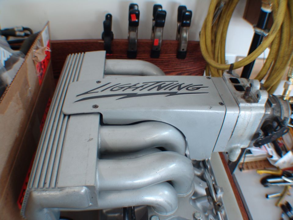 Ford Lightning supercharger and intake manifold assembly. Tools and a yellow hose are visible in the background