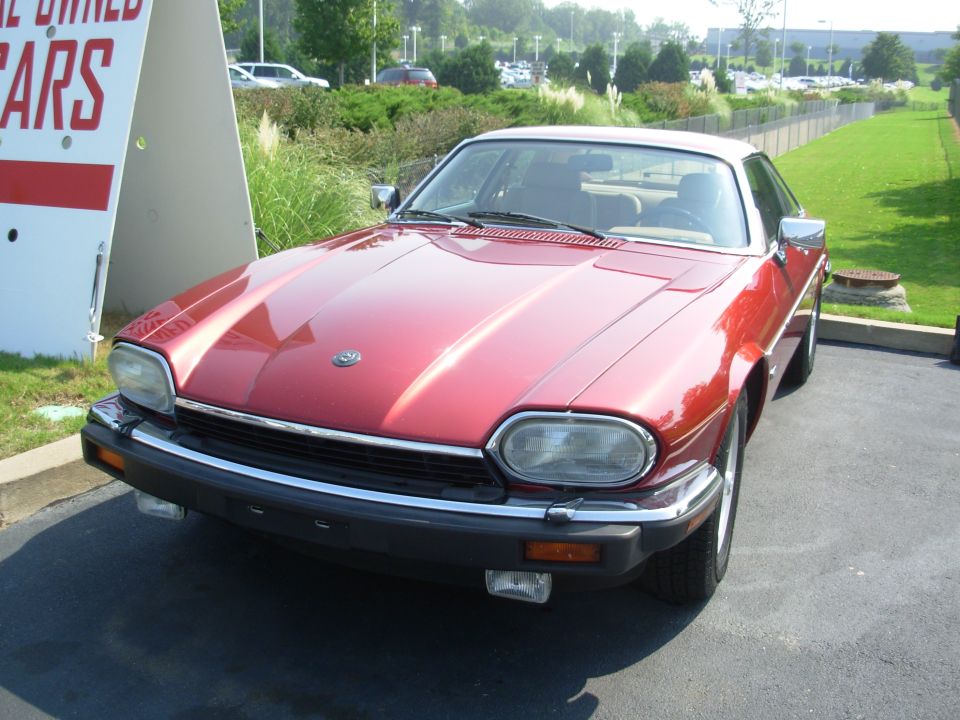 Dark red Jaguar XJ-S coupe, front three-quarter view in a parking lot