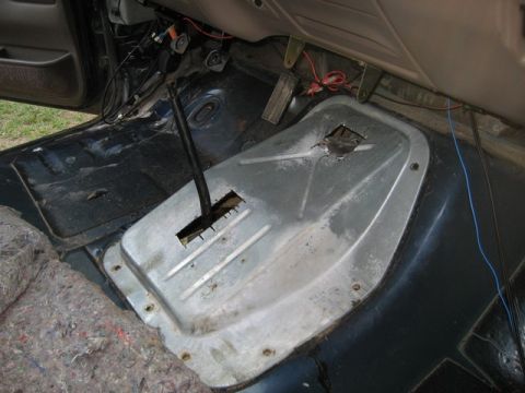 1995 Ford Bronco - Vehicle interior showing the transmission tunnel and floor area, with a gear shifter in place.
