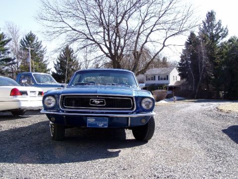 1968 Ford Mustang - Front view of a blue 1968 Ford Mustang, the iconic Mustang emblem on the grille and a visible license plate.
