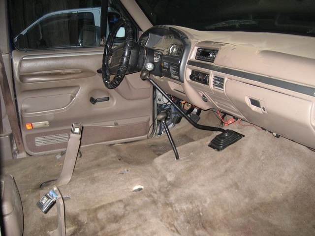 1995 Ford Bronco interior showing dashboard, steering wheel, and floor with removed carpet