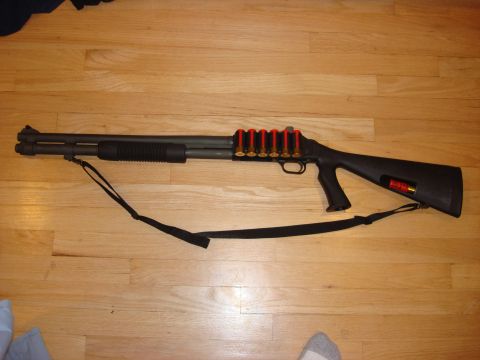 2003 Ford Crown Victoria - A shotgun is displayed on a wooden floor with a sling attached.