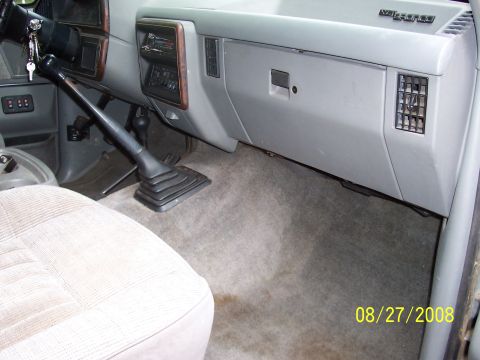 1988 Ford Bronco - Interior view of a truck's dashboard, showing the steering column, gear shift, and glove compartment.