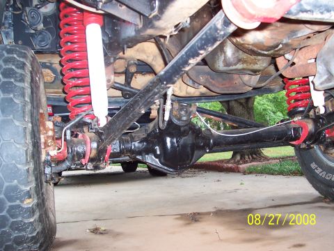 1988 Ford Bronco - Close-up view of the undercarriage, focusing on the suspension and axle components of a vehicle.