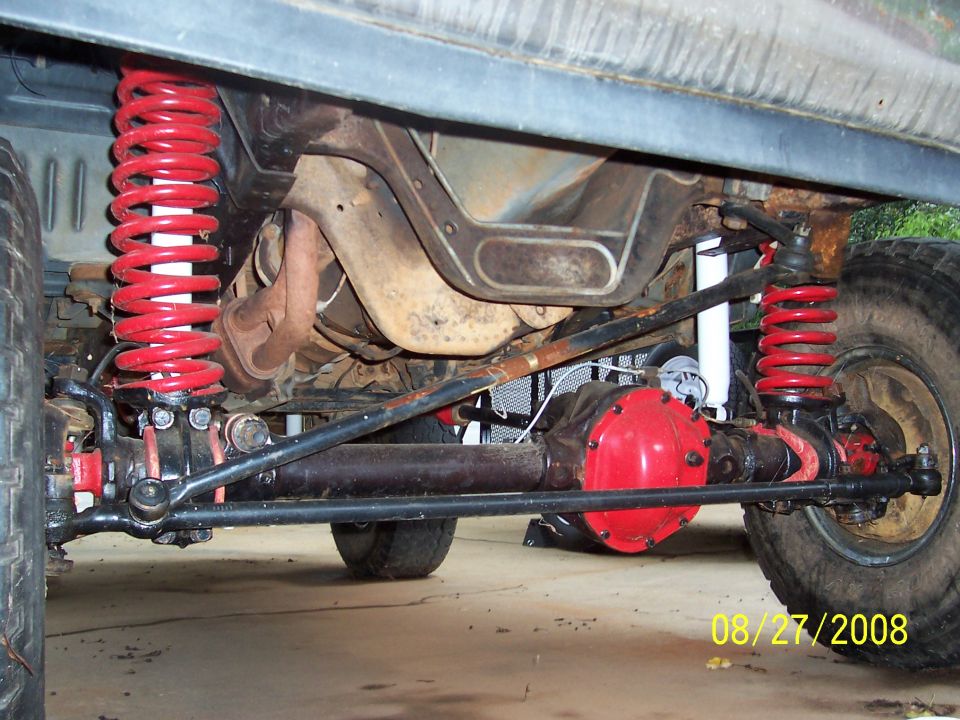 Underside view of red-painted differential and red coil springs on a 4x4 vehicle