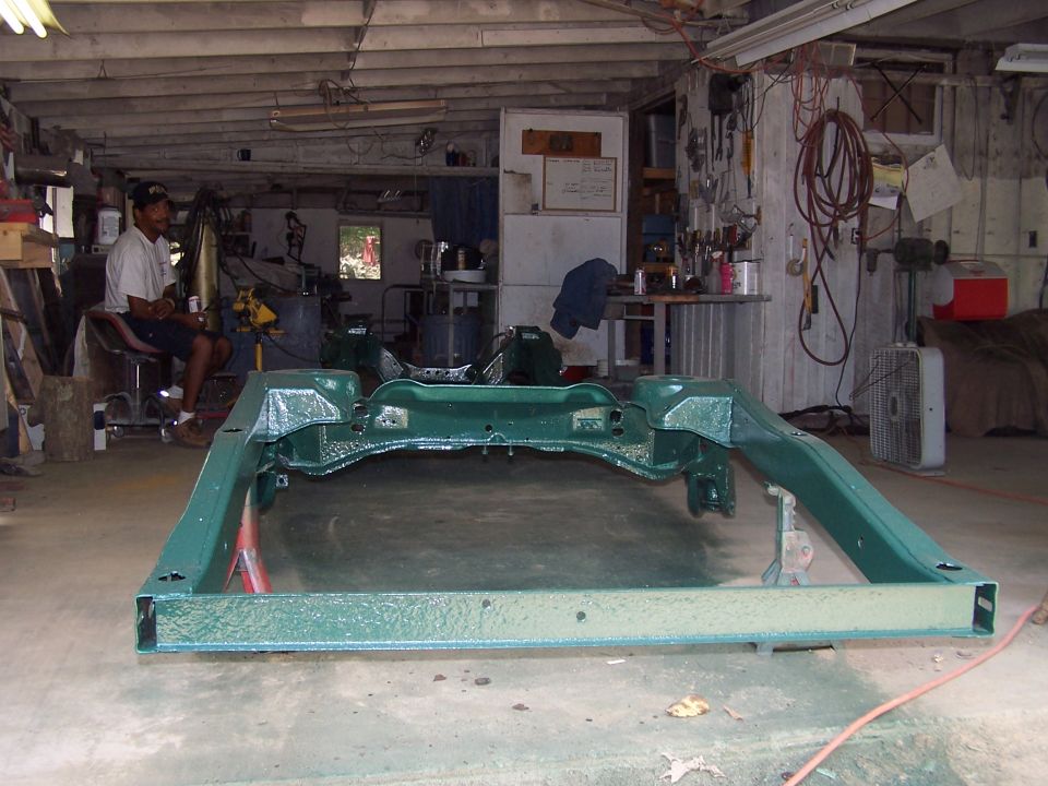 Freshly painted green vehicle frame on a garage floor