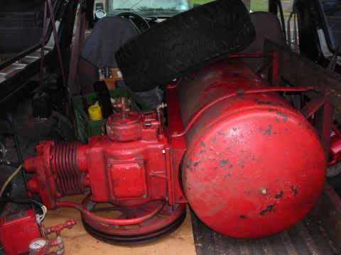 1995 Ford Bronco - An air compressor and spare tire are packed into the cargo area of a vehicle, obscuring the view of the interior.