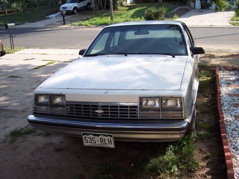 1972 Ford Ranchero - This white sedan has a distinct grille and headlight design, suggesting a model year around 1980.
