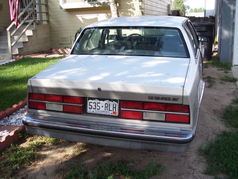 1972 Ford Ranchero - This Chevrolet sedan is parked in a driveway next to a trash can and a house.