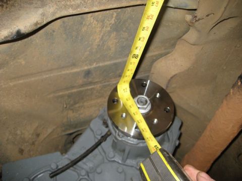 1995 Ford Bronco - A yellow tape measure is used to measure a flange on a transmission housing.