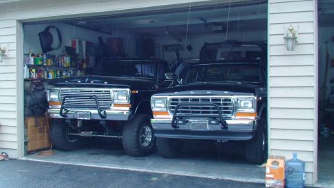 1979 Ford F-250 - Two black 1979 Ford F-250 pickup trucks are parked in a garage.