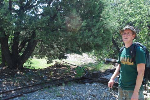 1997 Ford F-250 - A man stands in a wooded area next to old train tracks, wearing a hat and backpack.