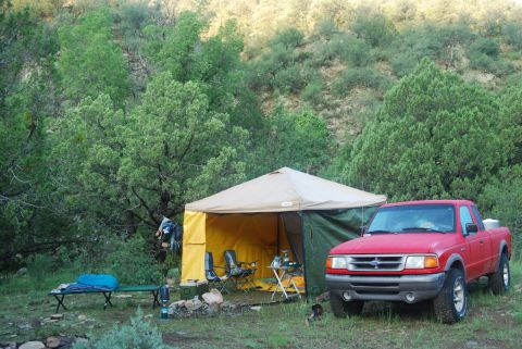 1997 Ford F-250 - A red pickup truck is parked at a campsite with a tent set up.