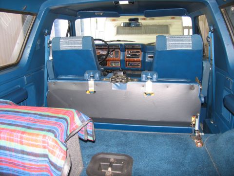 1984 Ford Bronco - The interior of a 1984 Ford Bronco, blue upholstery and wood-grain trim on the dashboard.
