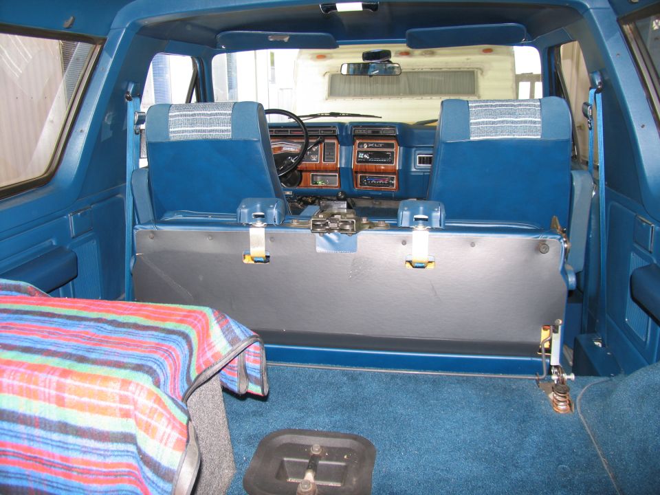 Interior of a 1984 Ford Bronco showing blue seats and dashboard