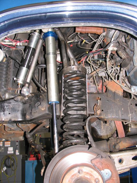 1984 Ford Bronco - Close-up view of a vehicle's front suspension system, showing various mechanical components.
