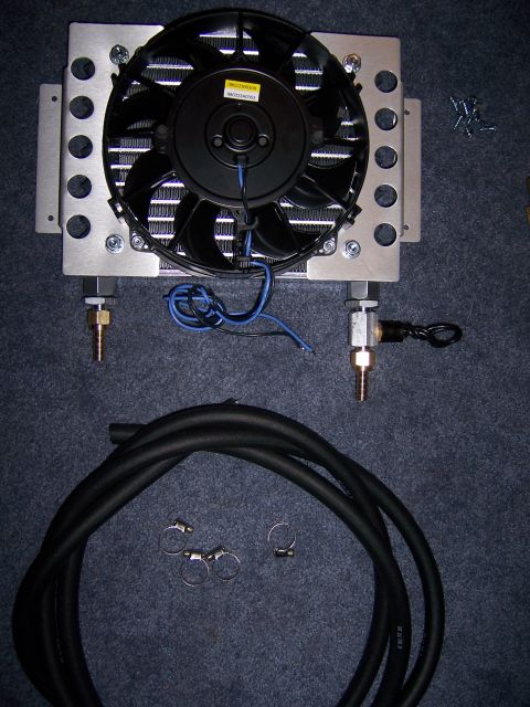 1991 Ford Bronco - A transmission cooler assembly, including a fan and hoses, is laid out on a dark surface.