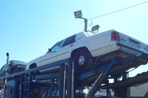 1991 Ford Crown Victoria LTD - White 1991 Ford Crown Victoria LTD loaded onto a car carrier with another vehicle below.