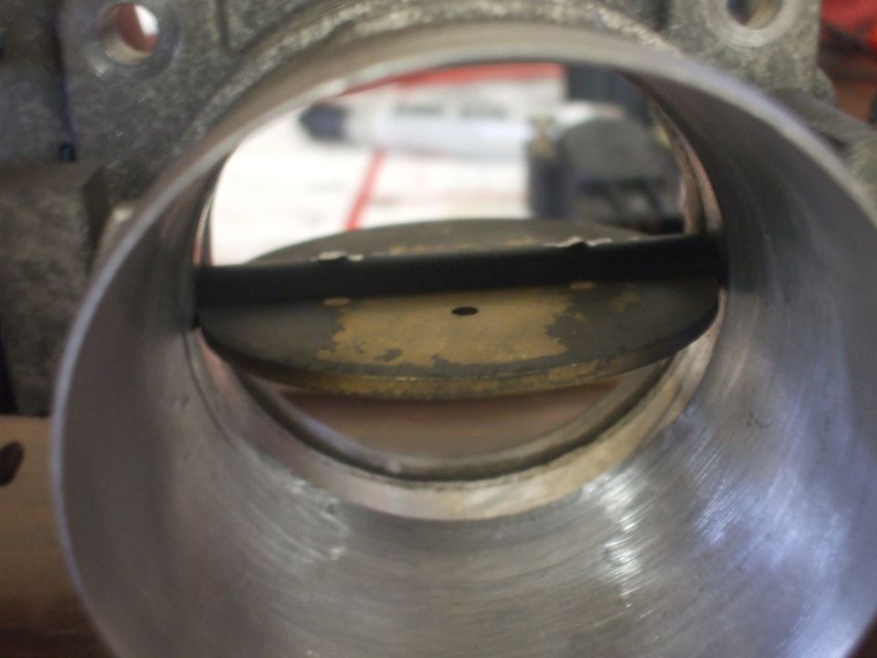 Close-up looking through a throttle body bore at the throttle plate