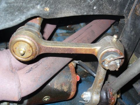 1968 Ford Mustang - Close-up of rusty suspension linkage and exhaust manifold, likely from a vintage vehicle.