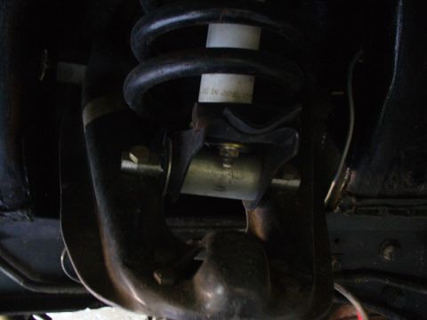 1968 Ford Mustang - This image shows a close-up view of a vehicle's suspension system, focusing on the shock absorber and coil spring.