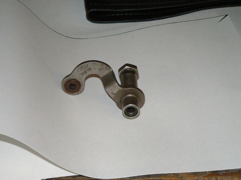 1978 Ford Ranchero - A metal bracket with a Ford logo is shown, attached to a bolt.