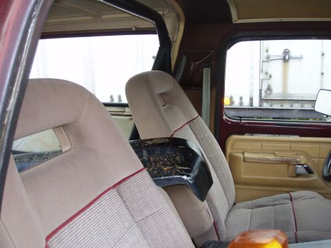 1979 Ford Bronco - The interior of a vehicle is shown, with a view of a trailer through the side window.