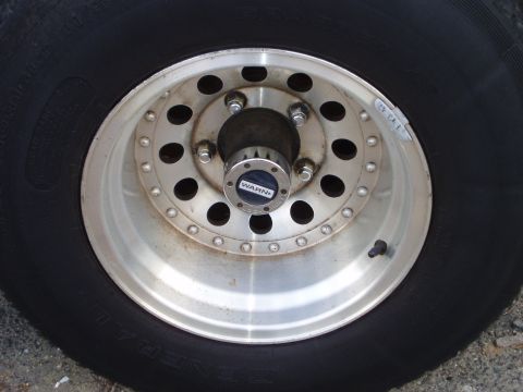 1979 Ford Bronco - A close-up view of a vehicle's wheel and tire, a WARN branded hubcap.