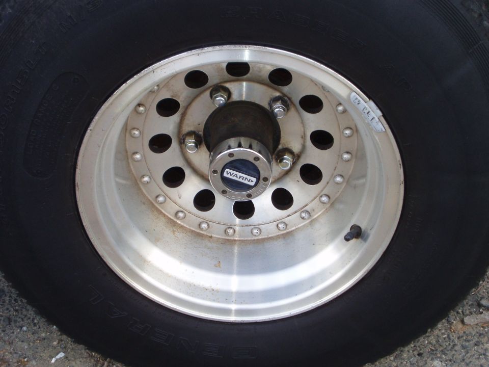 Close-up of a vehicle's wheel and tire with a WARN hubcap