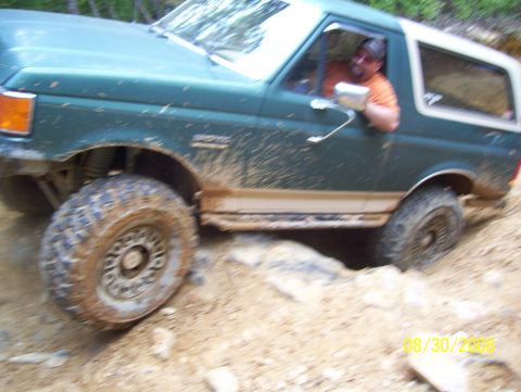 1978 Ford Bronco - A man drives a green Ford Bronco through a rocky, off-road trail.