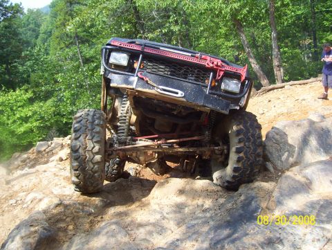 1978 Ford Bronco - This modified off-road vehicle navigates a challenging rocky terrain on a sunny day.