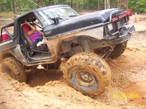 1978 Ford Bronco - A modified 1978 Ford Bronco struggles through a challenging mud obstacle during an off-road excursion.