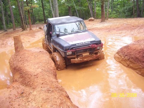 1978 Ford Bronco - Off-road vehicle navigates a challenging mud obstacle during an outing.