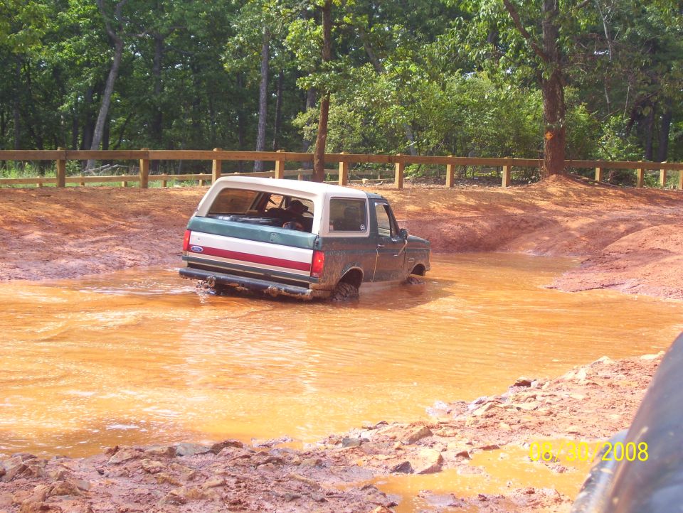 1978 Ford Bronco driving through mud puddle