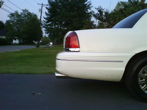 2003 Ford Crown Victoria - Rear view of a white 2003 Ford Crown Victoria showing its distinctive taillight and chrome accents.