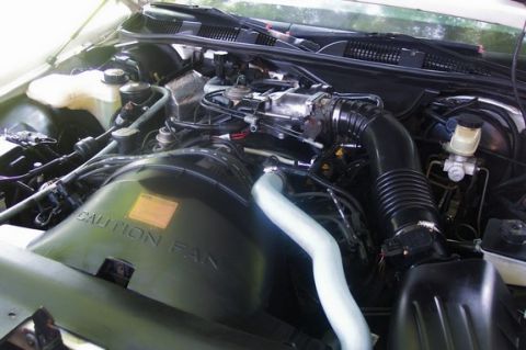 1996 Ford Crown Victoria - Close-up view of the engine compartment, showing various components and warning labels.