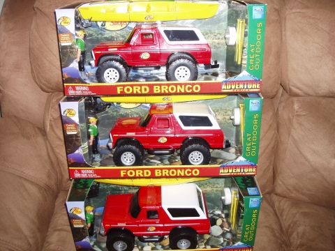 1979 Ford Bronco - Three boxed toy Ford Bronco models are displayed, each a red body, white top, and a kayak accessory.