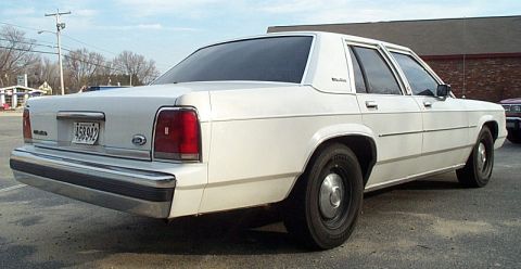 1991 Ford LTD Crown Victoria - White sedan with a chrome bumper and a license plate is parked outdoors.