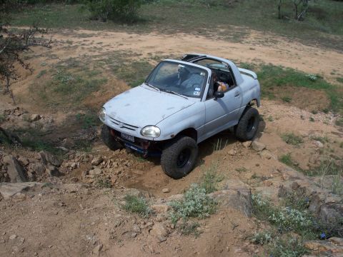 1996 Ford Bronco - This modified Suzuki X-90 is navigating a challenging off-road course with large tires and a raised suspension.