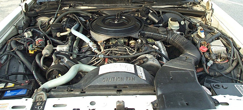 Ford V8 engine bay with round air cleaner, CAUTION FAN shroud and vacuum lines