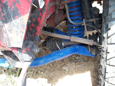 1996 Ford Bronco - A close-up view of a vehicle's suspension system, showing blue control arms and coil springs.
