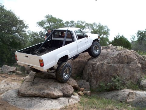 1996 Ford Bronco - Modified Toyota pickup truck navigates a rocky off-road course.