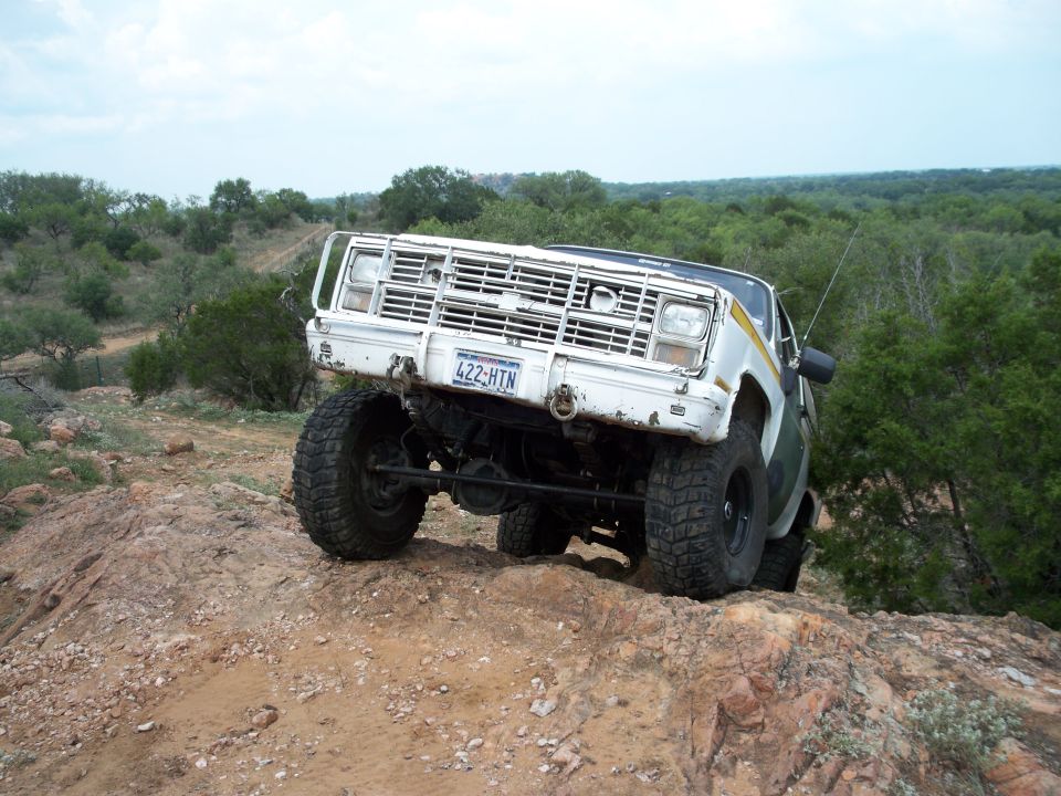 White off-road truck with brush guard and license plate 422-HTN on rocky terrain