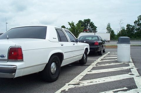1991 Ford LTD Crown Victoria - A white 1991 Ford Crown Victoria LTD is seen from the rear, parked next to a black sedan.