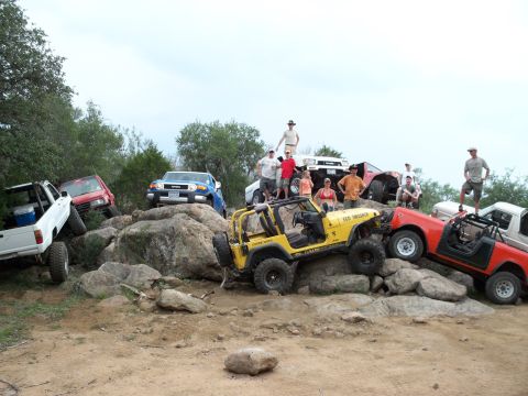 1996 Ford Bronco - A group of people pose with their off-road vehicles on a rocky terrain.