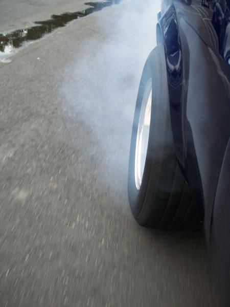 1970 Ford Mustang - A 1970 Ford Mustang's rear tire smokes as it spins on the asphalt.