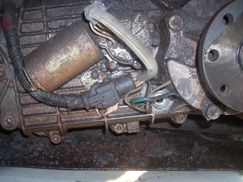 1992 Ford Bronco - This is a close-up view of a transfer case actuator, covered in grime and dirt.