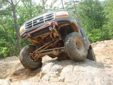 1995 Ford Bronco - This modified 1995 Ford Bronco navigates a rocky trail with its front wheels high off the ground.